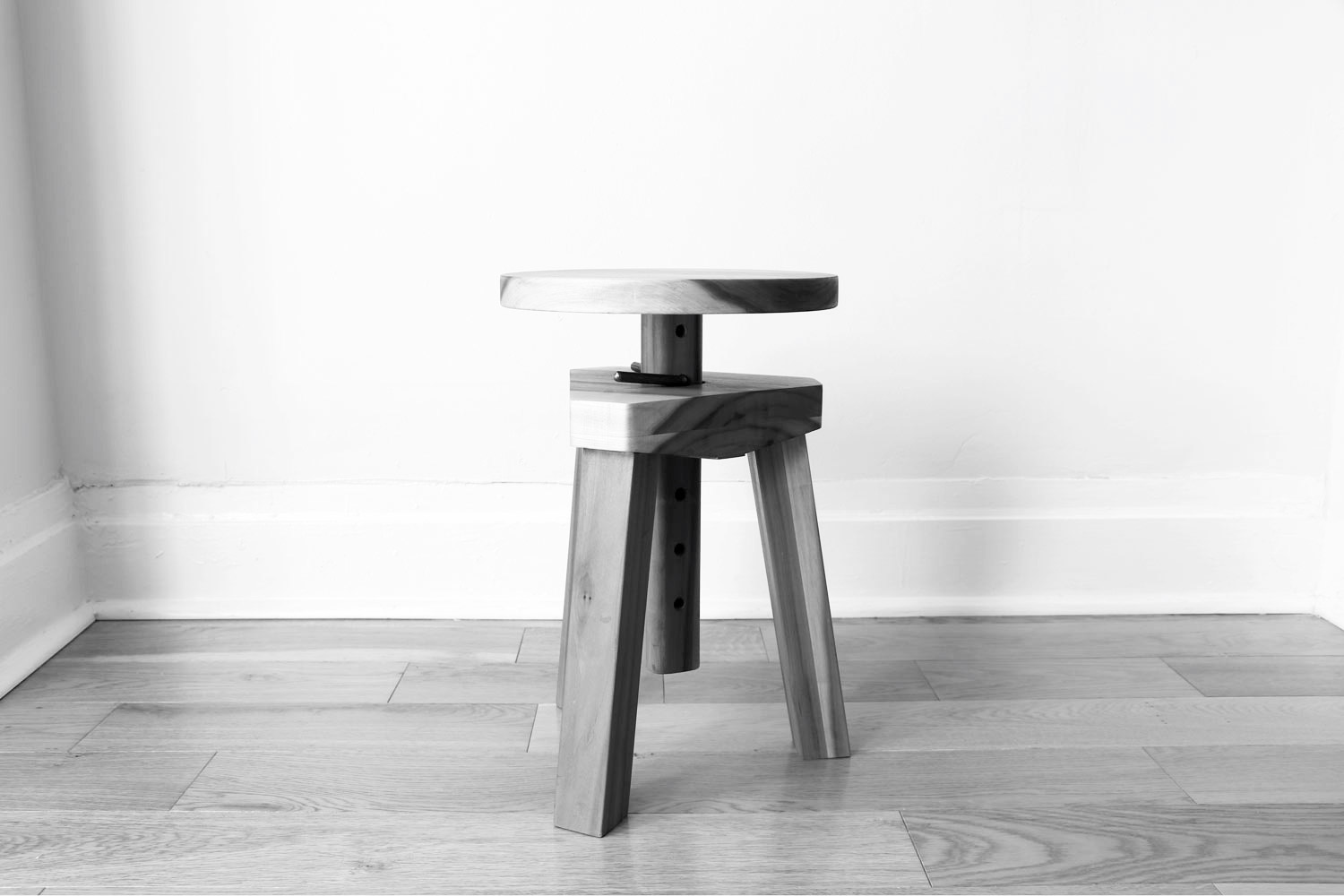 a wooden stool with three legs and adjustubale seat