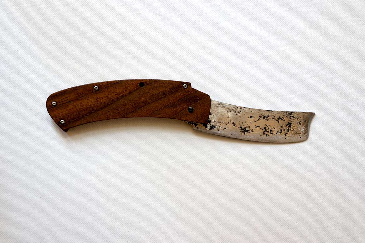 a handmade carbon steel folding knife with wood handle